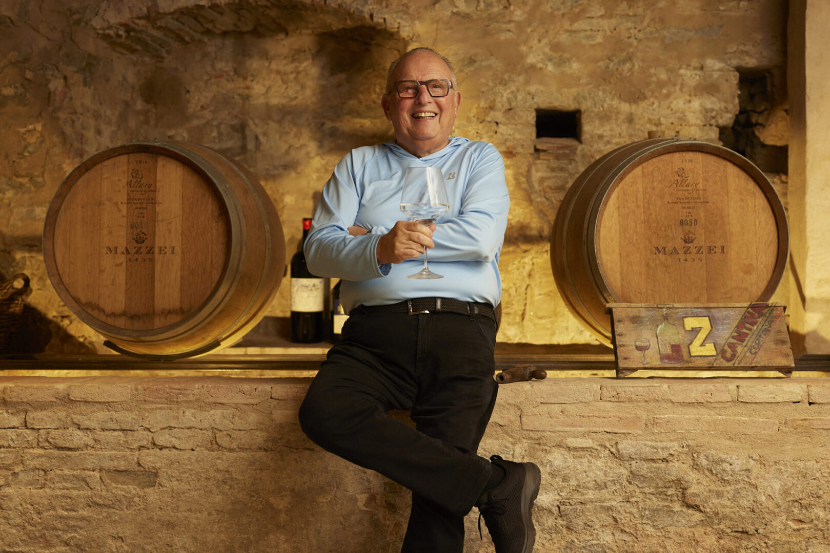 A man sitting on the wall of a wine cellar.