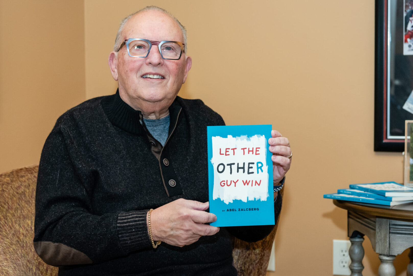 A man holding up a book that says " let the other buy him ".